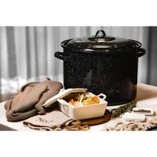 Speckled black stock pot with lid and side handles on countertop
