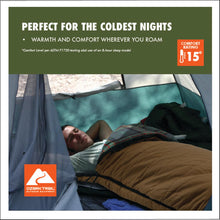 Tan cold-weather sleeping bag spread on a bed inside a tent