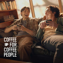 Coffee mugs with Peet's dark roast coffee, held by two people