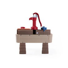 Pump and Splash discovery water table with red hand pump and brown legs on beige base.