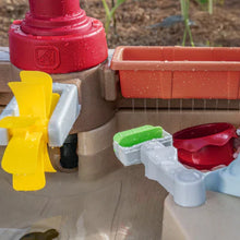Pump and Splash water table close-up with yellow funnel and green cup fixtures on rim.