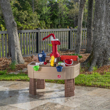 Kids outdoor water play table with red hand pump and beige basin, cups included