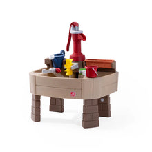 Pump and Splash discovery water table with red pump and colorful accessories on beige base.