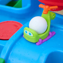 Green toy launcher cradling white ball in blue water slide pool with purple supports