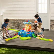 Outdoor water play activity center with green rails and yellow chute, kids using tools