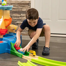 Toy water play center with green track and red cup pieces, child operating part