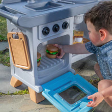 Blue BBQ play cart with open side door, toy burger, fries, and front control knobs
