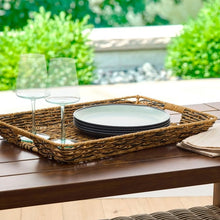 Rectangular rattan-style serving tray holding a plate and utensils