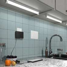 Black wall charger mounted on a backsplash with ports facing outward