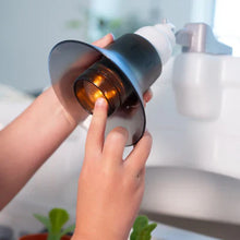 Hand pouring from toy faucet into the sink basin