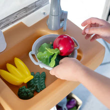 Toy sink basin with green lettuce, red pepper, and bowl being filled