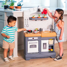 Kids' play kitchen set with pots, cups, and utensils on the counter