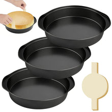 Stacked black round cake pans with parchment circle cutout