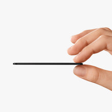 Black Chipolo LOOP tracker held in hand, slim profile with side edge