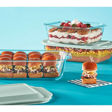 Rectangular glass baking dish with lid, filled with dessert topped with strawberries