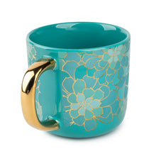 Teal ceramic coffee mug with gold floral pattern and curved gold handle