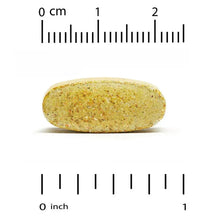 Single oval yellow-green multivitamin tablet beside inch ruler scale
