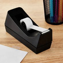 Black desktop manual tape dispenser on wood with white tape roll loaded