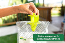 Fly trap with green top cap lifted open on white mesh bag