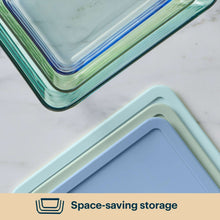 Stacked tinted plastic containers with blue and green rims, corner close-up
