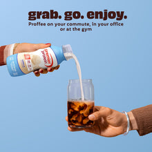 Vanilla protein shake bottle pouring into a glass held by hands