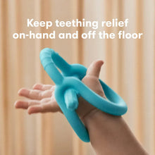 Teether ring toy held in hand, teal-blue grip handles with textured bumps