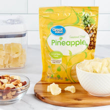 Sweetened dried pineapple pouch with dried pineapple pieces on board