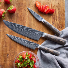 Stainless utility knives with wood handles on wooden board with strawberries