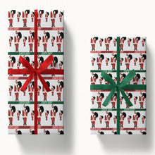White wrapping paper with repeating Santa figures and red and green bands, shown on wrapped gifts.