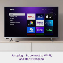Roku streaming interface on TV screen with remote placed on stand