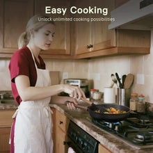 Black nonstick frying pan on a gas stovetop with cooking food