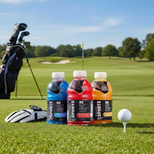 Three sports electrolyte drink bottles on grass: mixed berry, fruit punch, and orange