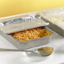 Aluminum foil-lined food pan with baked contents and serving spoon
