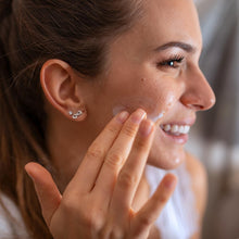 Woman applying moisturizing water gel to her cheek and under-eye area