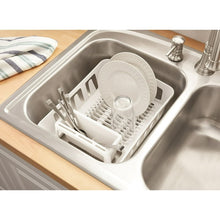 White dish drying rack with plate supports, utensil slots, and draining tray over sink