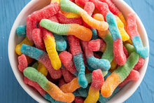 Bowl of colorful gummy candy worms in red, orange, green, blue, and yellow