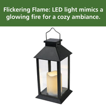 Black solar lantern with lit candle effect inside, glass panels and arched metal handle.