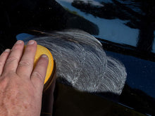 Foam pad buffing a dark car paint surface with fine swirl marks