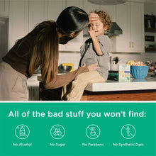 Kids cold & cough syrup bottle on kitchen counter near a child and caregiver