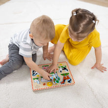 Two children kneeling on the floor playing with a farm animal sound puzzle