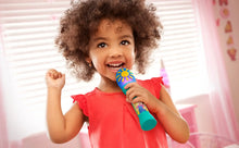 Toddler smiling and holding a teal microphone with yellow sun light panel