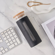 Black glass tumbler with bamboo lid and black silicone sleeve, with clear straw