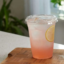 Clear plastic cup with sip lid, filled iced drink with citrus slice