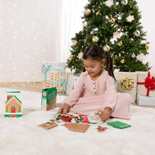 Child assembling wooden gingerbread house play set on a table