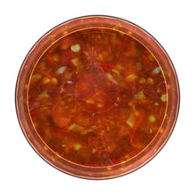 Glass bowl of medium salsa with chunky red tomato pieces and green flecks