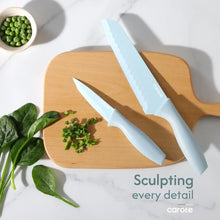 Light blue ceramic carving knife with herb garnish on wooden board