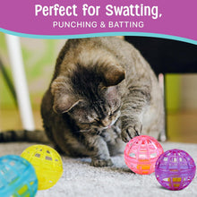 Grey cat swatting pink and purple lattice bell balls on a carpeted floor
