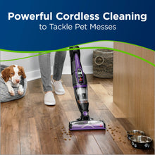 Purple cordless stick vacuum with floor brush cleaning hard floors