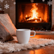 White coffee mug with curved handle resting on a soft blanket.