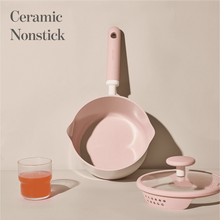 Pink-lidded ceramic nonstick saucepan and small pot with white body and pink handles